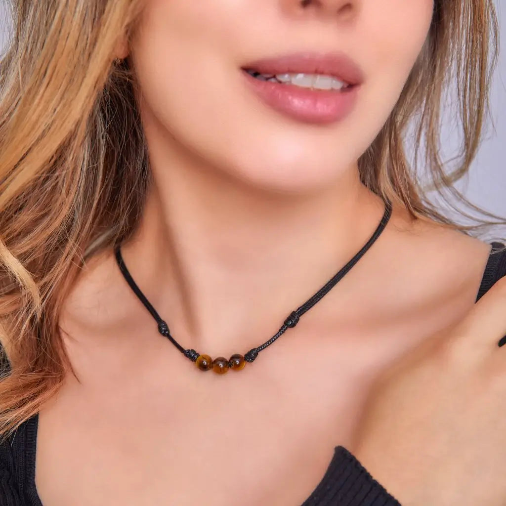 Women showcasing a Tiger Eye Choker, with the stone's distinctive golden-brown shimmer accentuating their stylish and confident look - Luck Strings