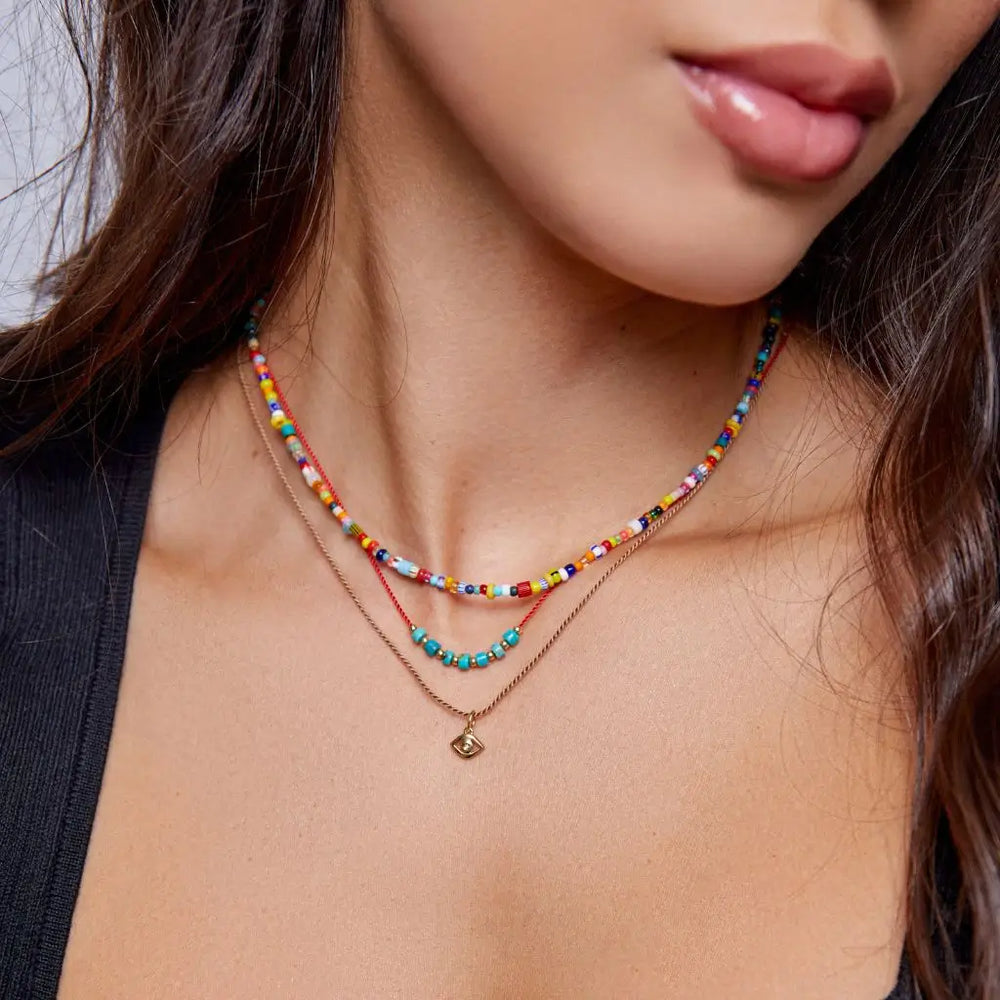 Female model layering the Evil Eye Diamond Necklace with chokers. - Luck Strings