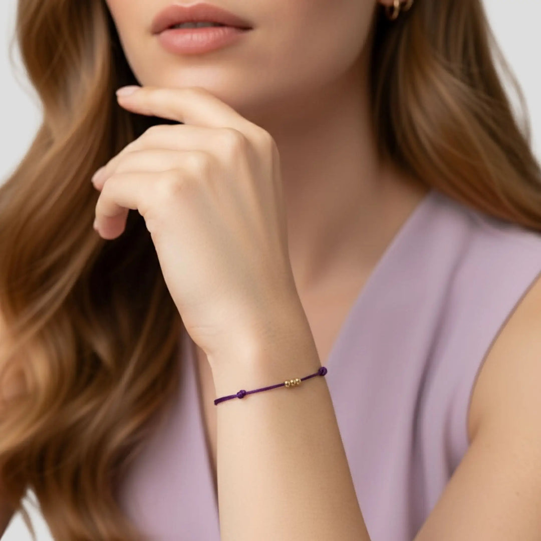 Close-up of a woman wearing a purple bracelet with a blurred background