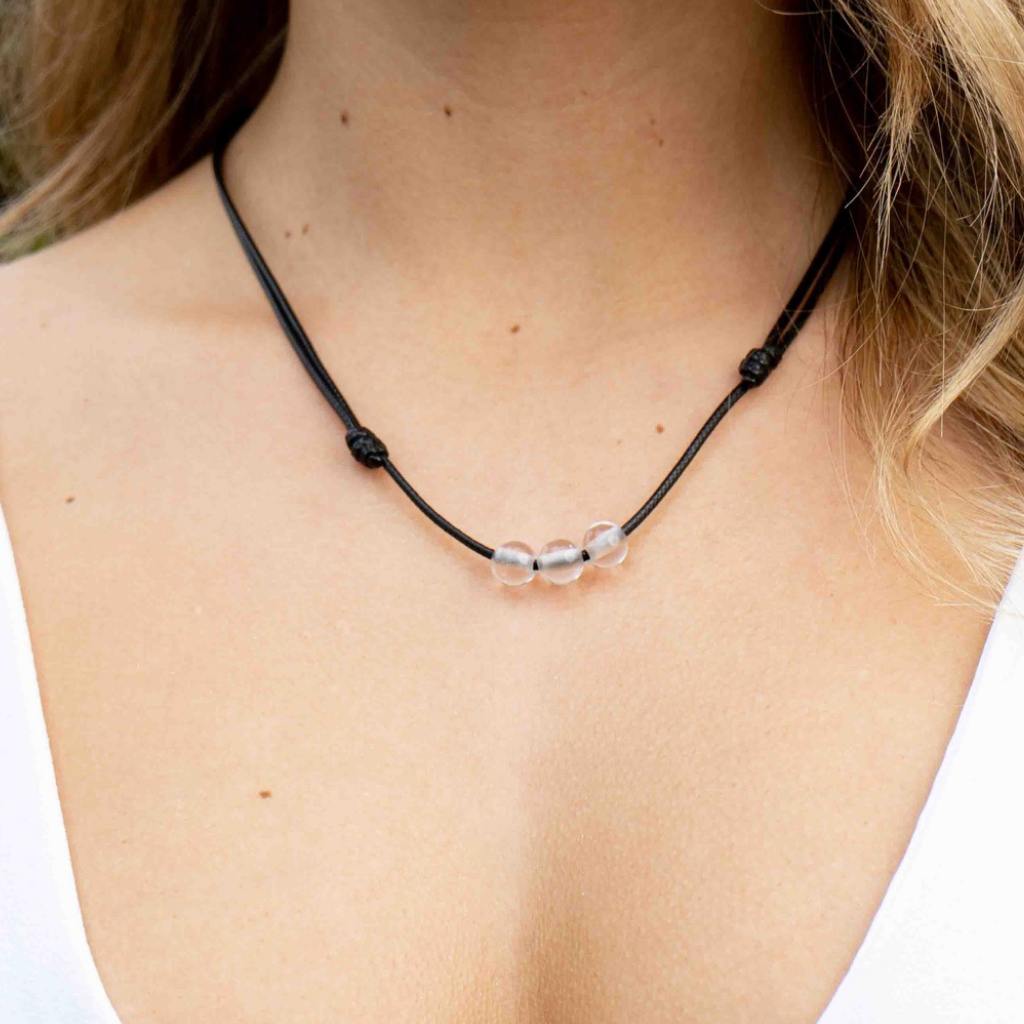Woman gracefully wearing a Clear Quartz Beaded Choker, highlighting its luminous beads and adding a touch of refined elegance to her look - Luck Strings