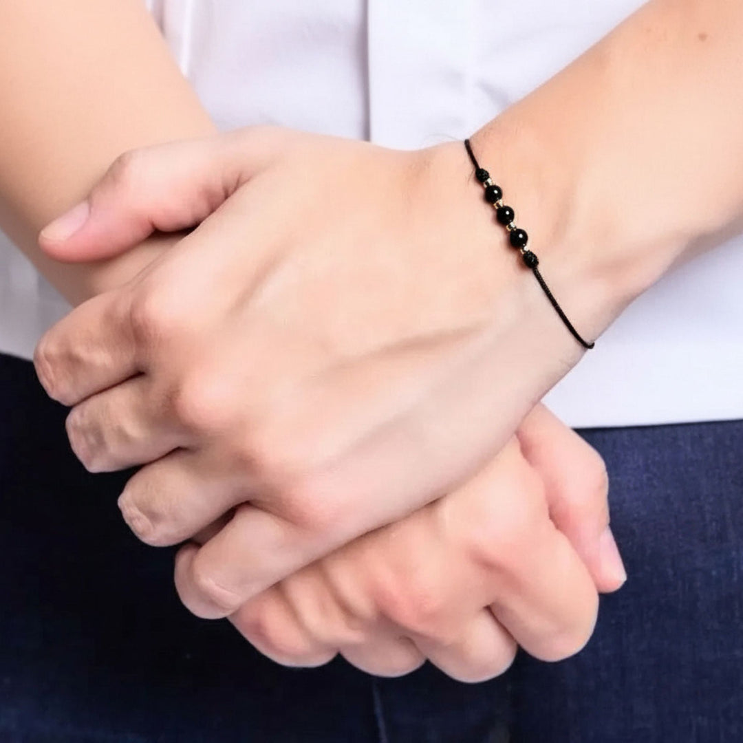 Two hands holding each other with a close-up focus on the wrists.