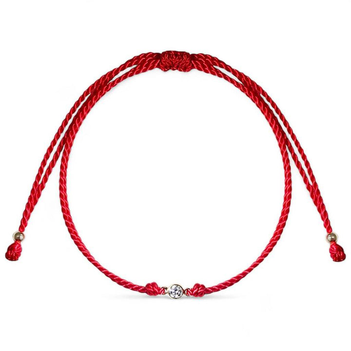 Close-up of a 14K Gold Diamond Bezel Red String Bracelet, featuring a 3mm 1/10 CT natural diamond and vibrant red string, symbolizing luck and protection with adjustable macrame knots – Luck Strings.