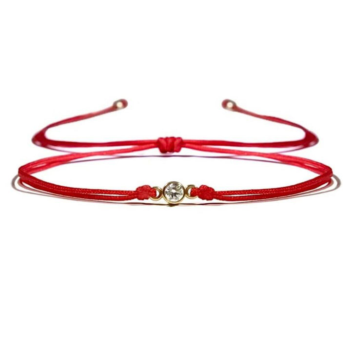 Close-up of a 14K Gold Diamond Bezel Red String Bracelet, featuring a 3mm 1/10 CT natural diamond and vibrant red string, symbolizing luck and protection with adjustable macrame knots – Luck Strings.
