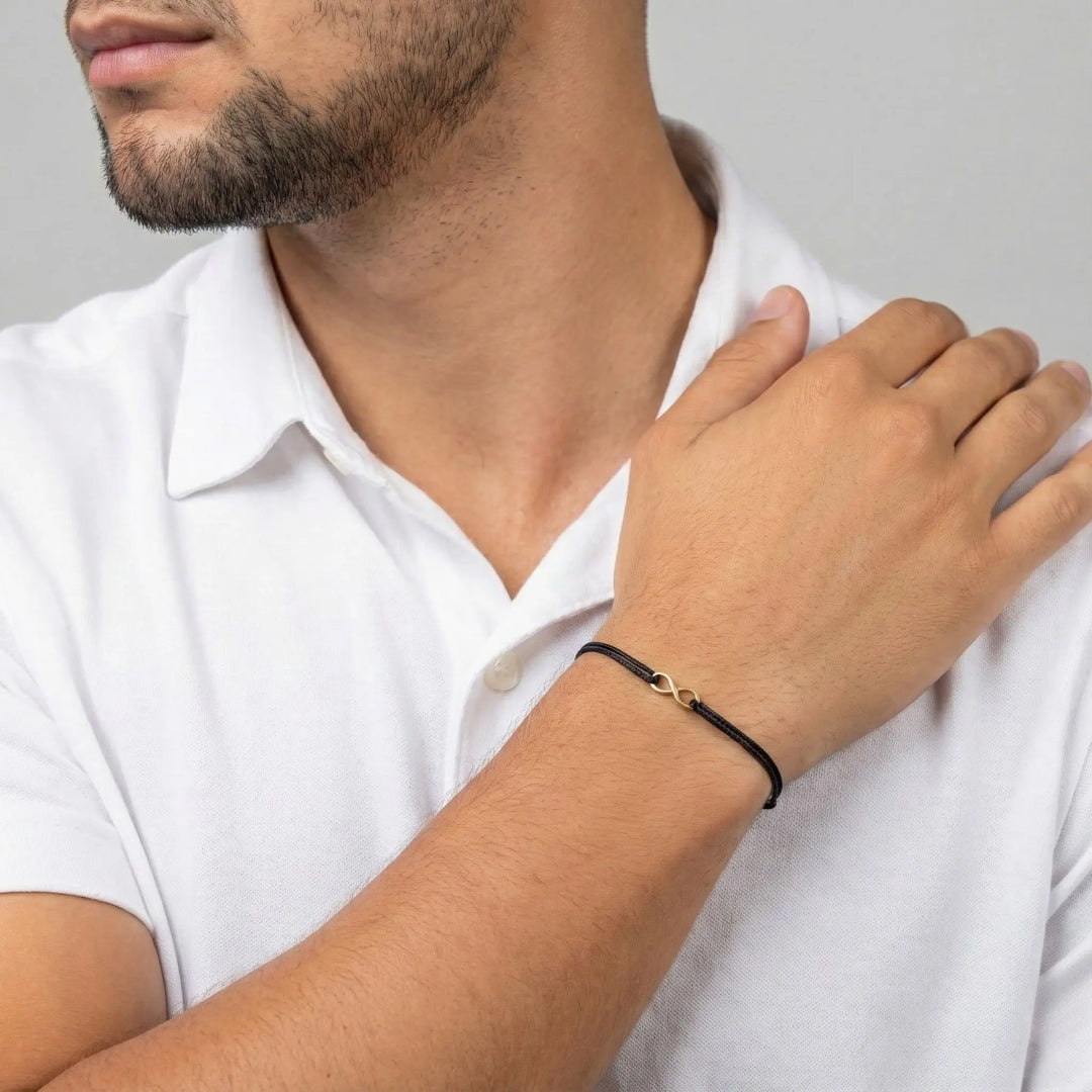 Man wearing a white shirt with a black bracelet on his wrist.