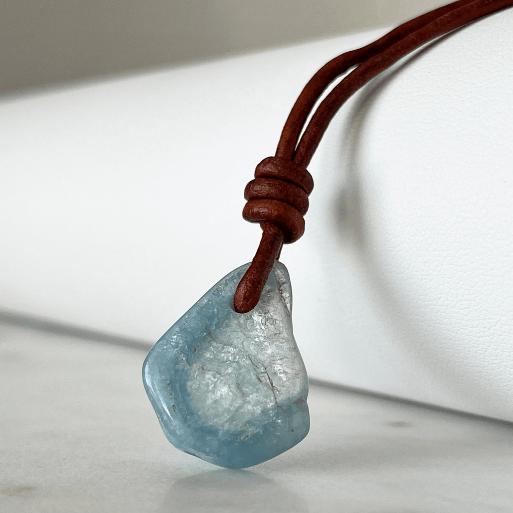 Unique one-of-a-kind raw aquamarine pendant with natural ocean-blue hues, showcasing the gemstone's unpolished beauty on a delicate cord - Luck Strings.