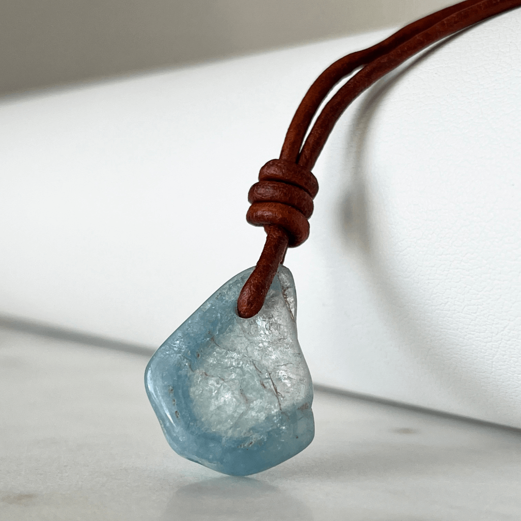 Unique one-of-a-kind raw aquamarine pendant with natural ocean-blue hues, showcasing the gemstone's unpolished beauty on a delicate cord - Luck Strings.
