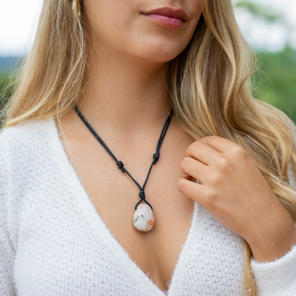 Woman wearing a Sunstone necklace with adjustable black cord over a white sweater - Luck Strings