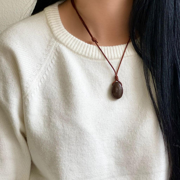 Close-up of a woman wearing a Dinosaur Bone Necklace with an adjustable distressed brown leather cord - Luck Strings