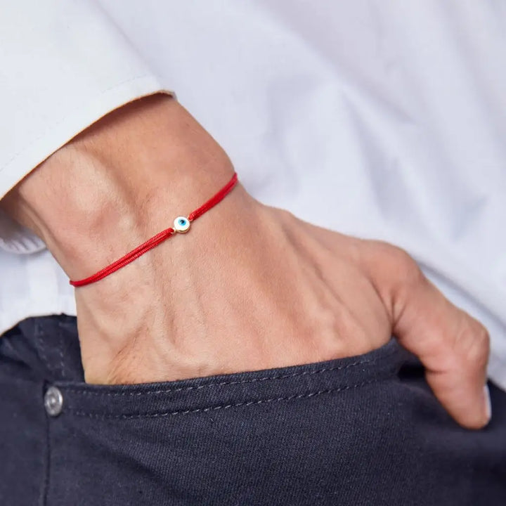 men wearing a red gold evil eye bracelet