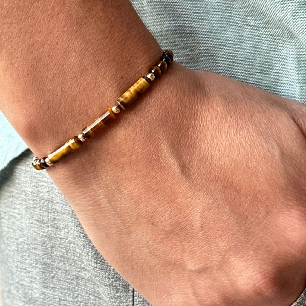 Close-up of the Tiger Eye 14K Gold Bracelet on a man's wrist, displaying the warm, earthy tones of the tiger eye beads alongside the sparkle of gold - crafted by Luck Strings.