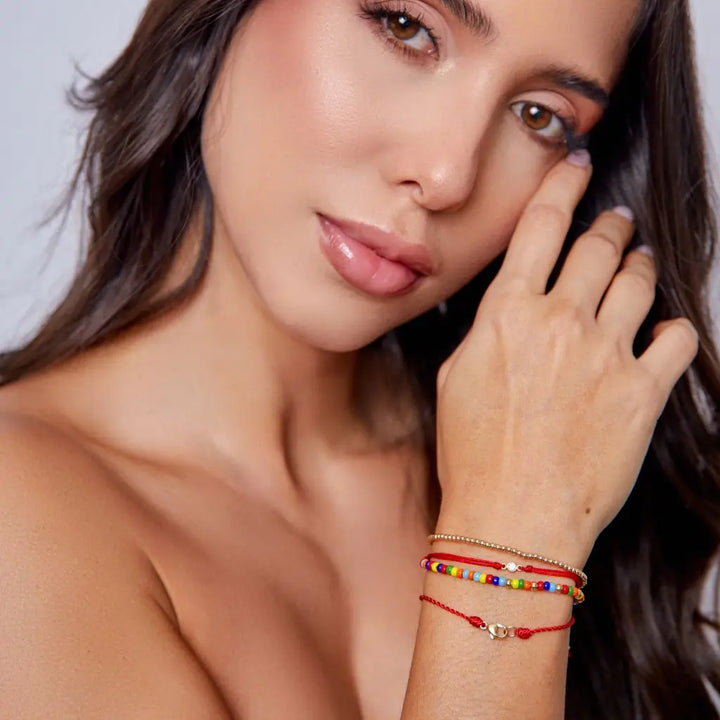 Woman displaying a 14K Gold Diamond Bezel Red String Bracelet, highlighting the elegance and powerful protection of the vibrant red string – Luck Strings