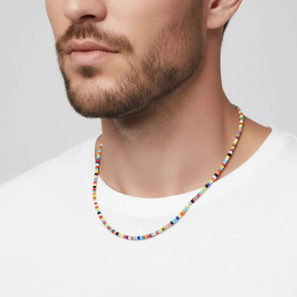 Man wearing a colorful beaded necklace against a plain background