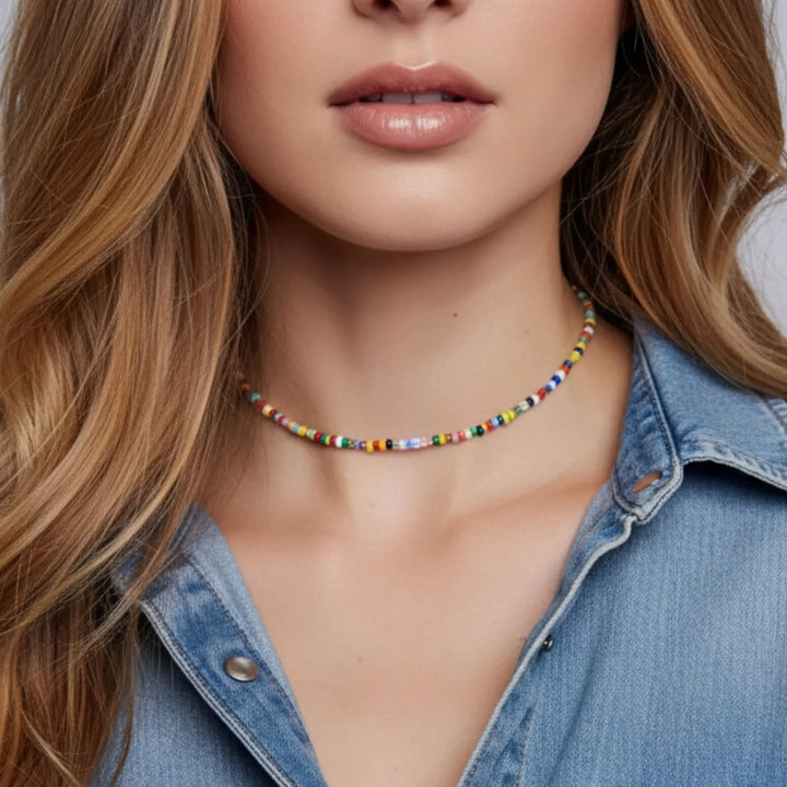 Close-up of a woman wearing a colorful beaded necklace with a denim shirt.