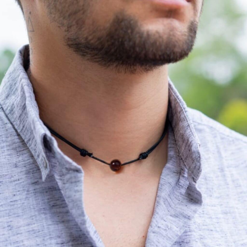 Man wearing a Luck Strings Unisex Beaded Choker, showcasing a variety of gemstones on an adjustable cord, reflecting a blend of style and diverse energies.