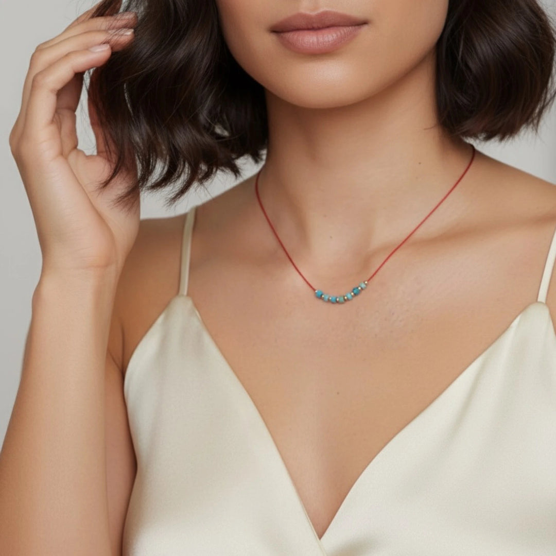 Woman wearing a delicate necklace with a plain background