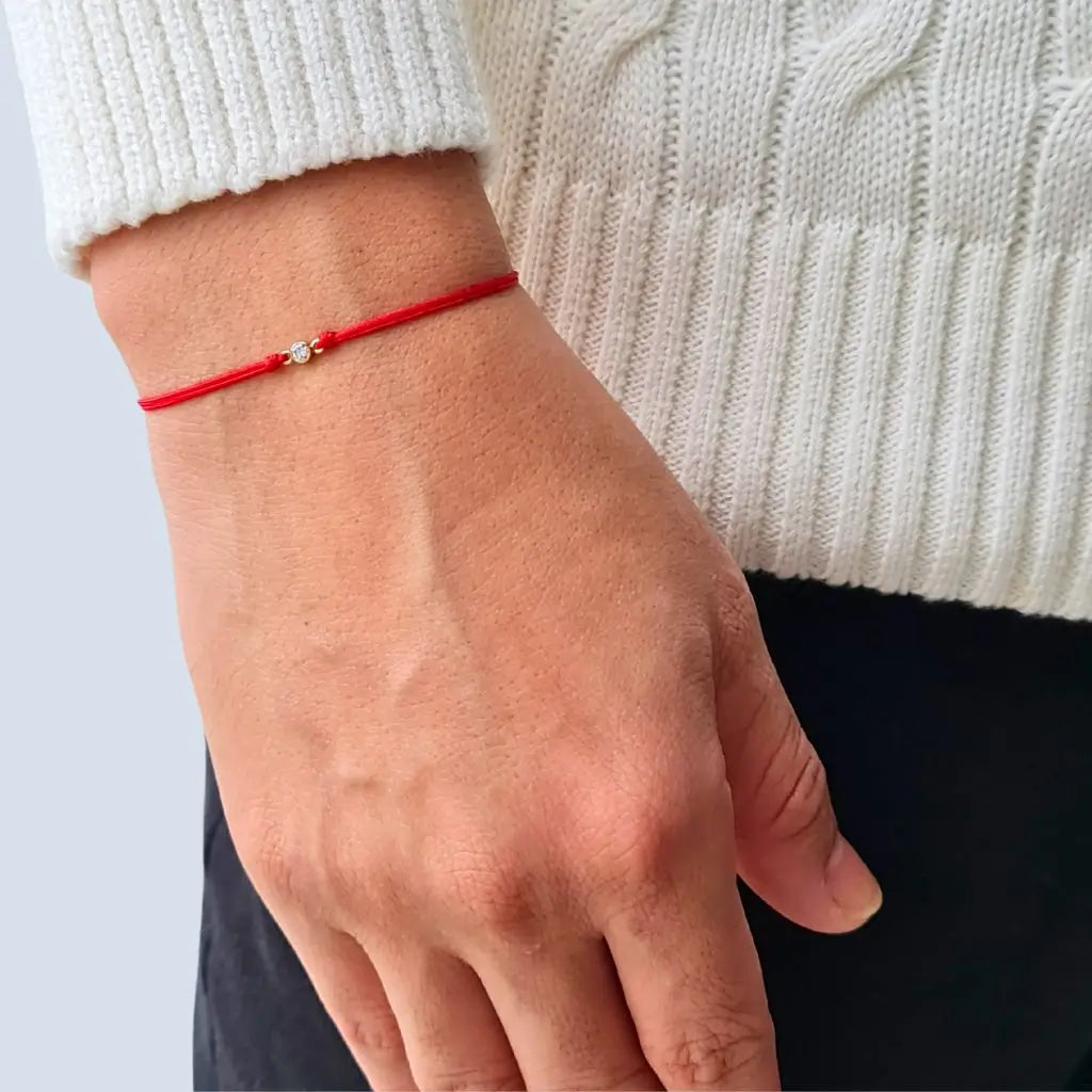 Man wearing a 14K Gold Diamond Bezel Red String Bracelet, showcasing the elegance and protective symbolism of the vibrant red string – Luck Strings.