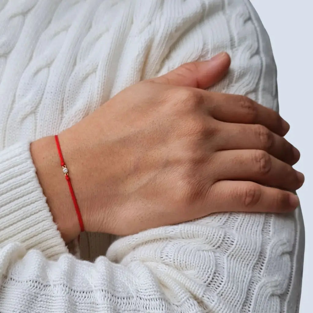 Man wearing a 14K Gold Diamond Bezel Red String Bracelet, showcasing the elegance and protective symbolism of the vibrant red string – Luck Strings.