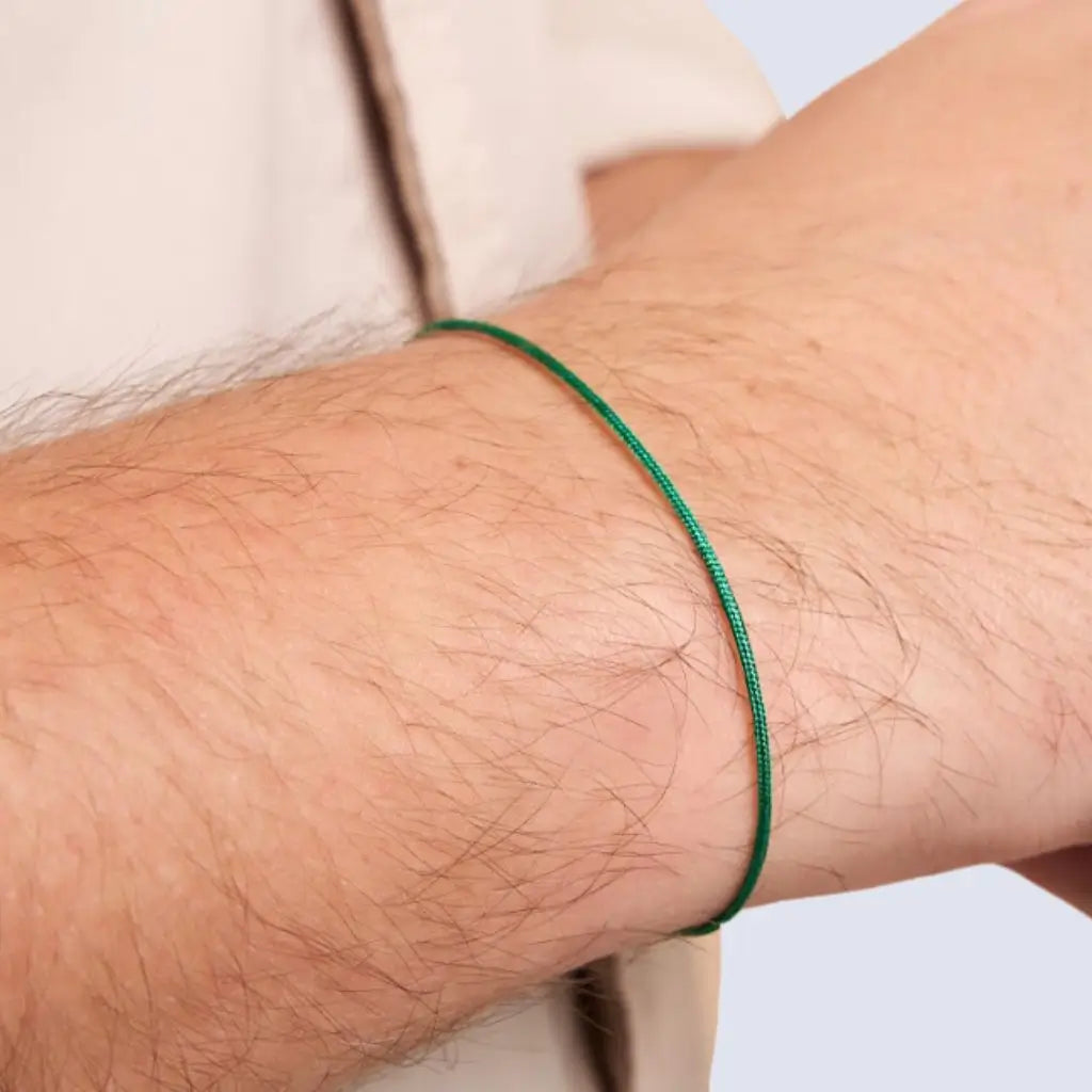 Person wearing a classic green string bracelet with a 14K solid gold clasp on their wrist - Luck Strings