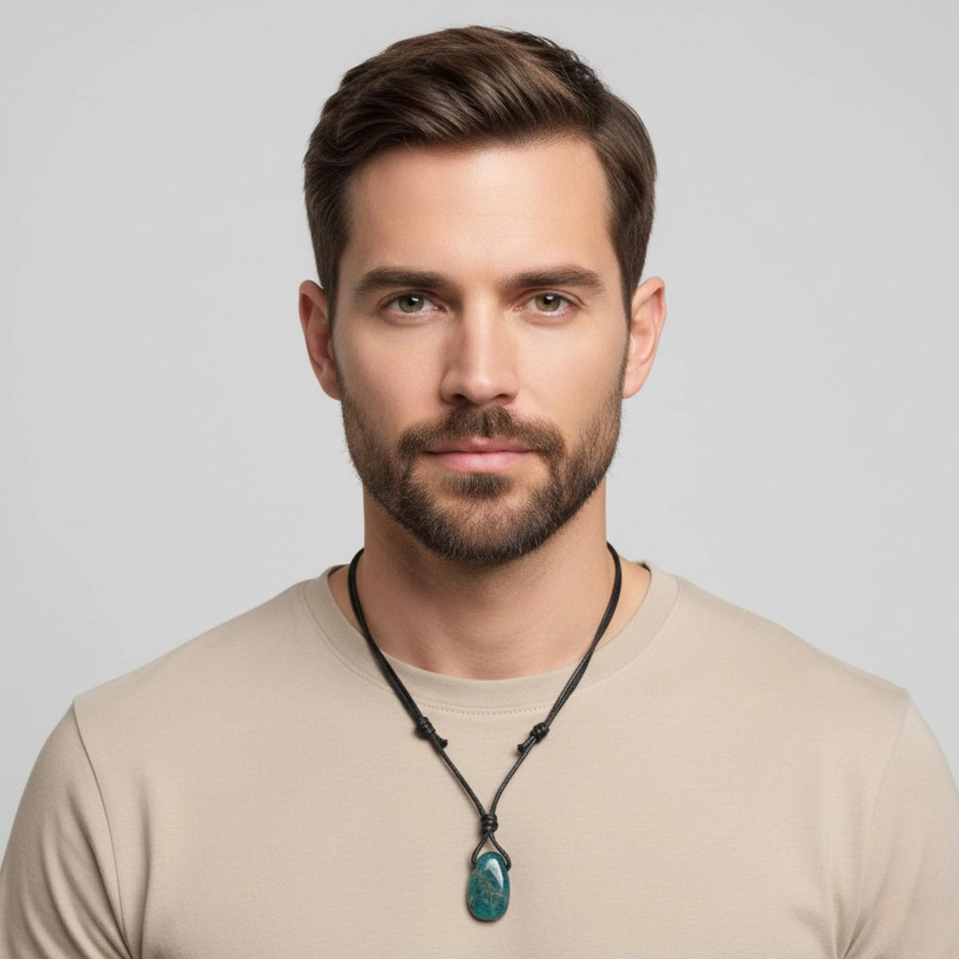 Man wearing a necklace with a green Apatite pendant against a gray background