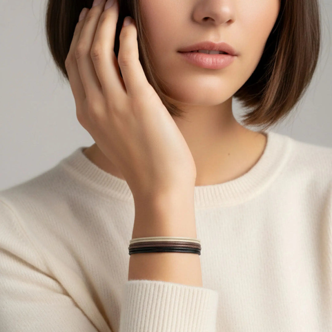Woman wearing a bracelet on a plain background