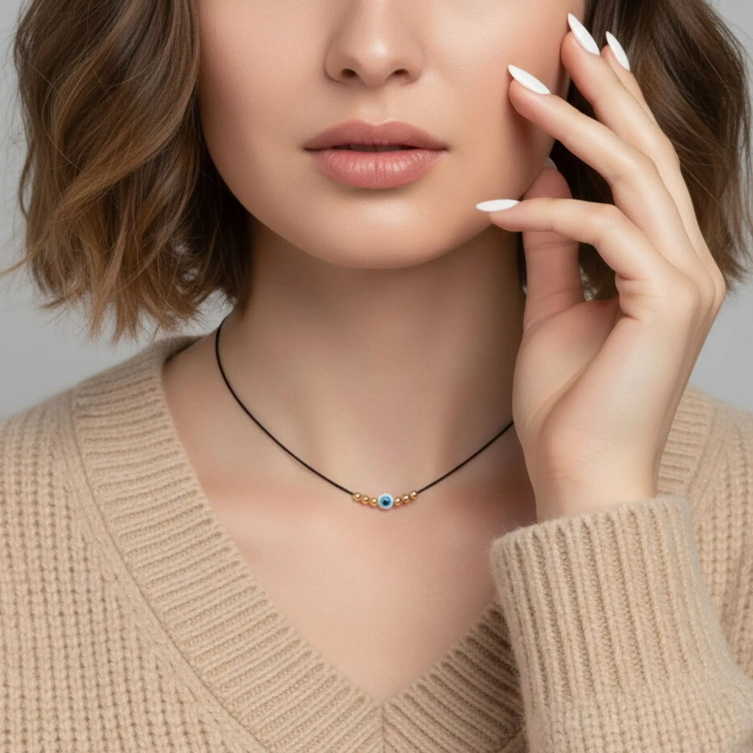 Woman wearing a delicate necklace with a neutral background