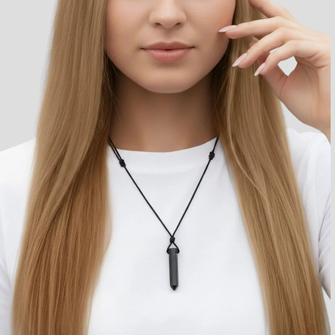 Woman wearing a black tourmaline  point necklace with a pendant on a white background