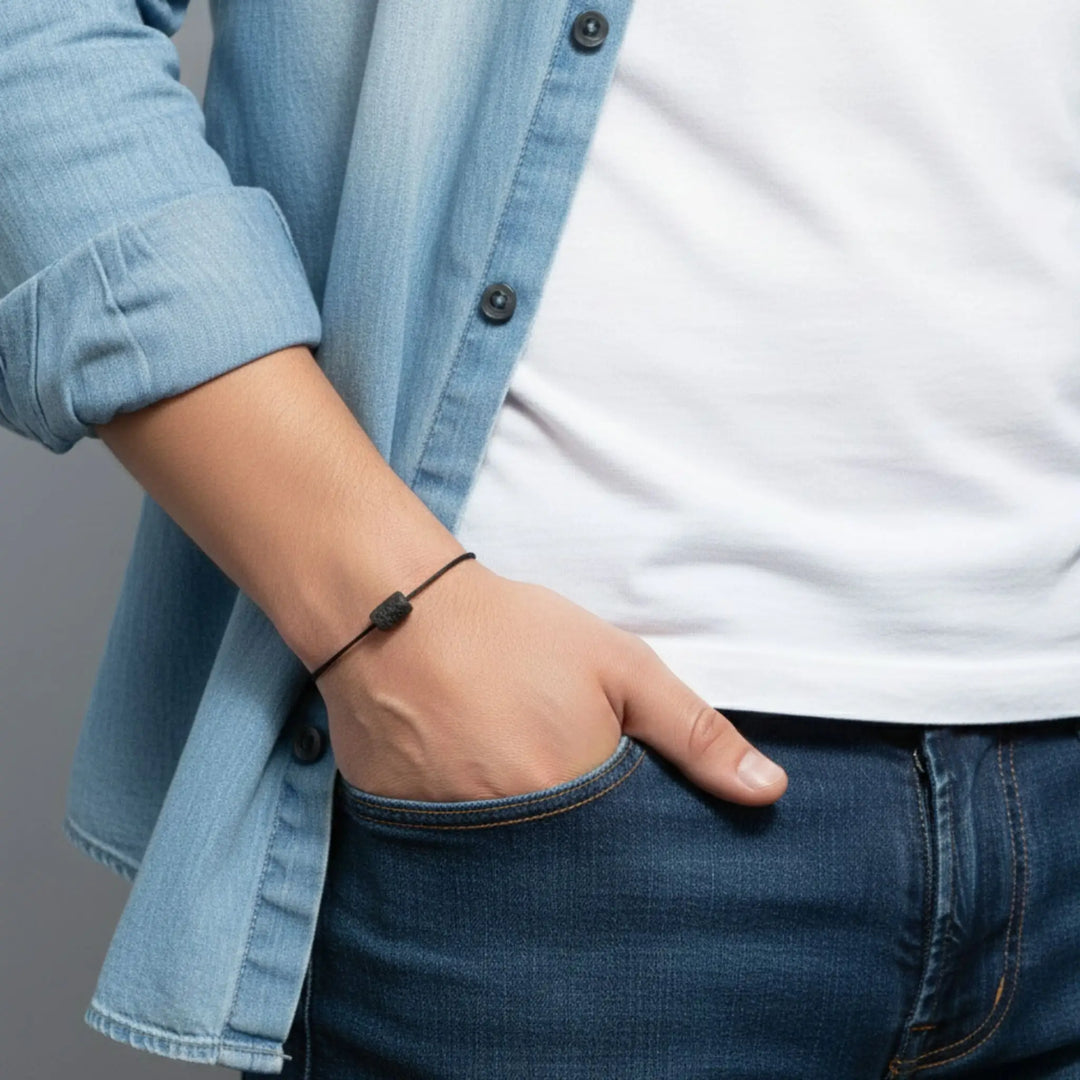 Man wearing raw black tourmaline bracelet on black cord, casual lifestyle view.
