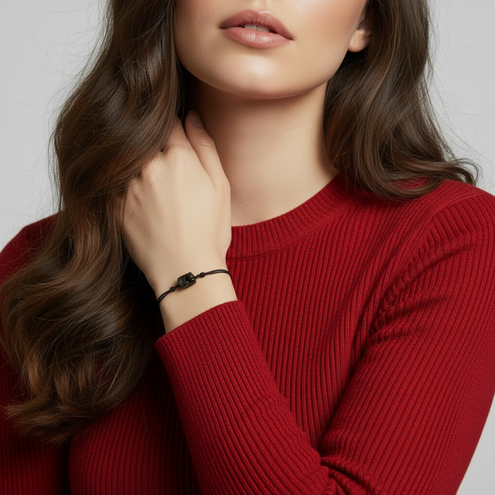Woman wearing raw black tourmaline bracelet on black cord, minimalist lifestyle.
