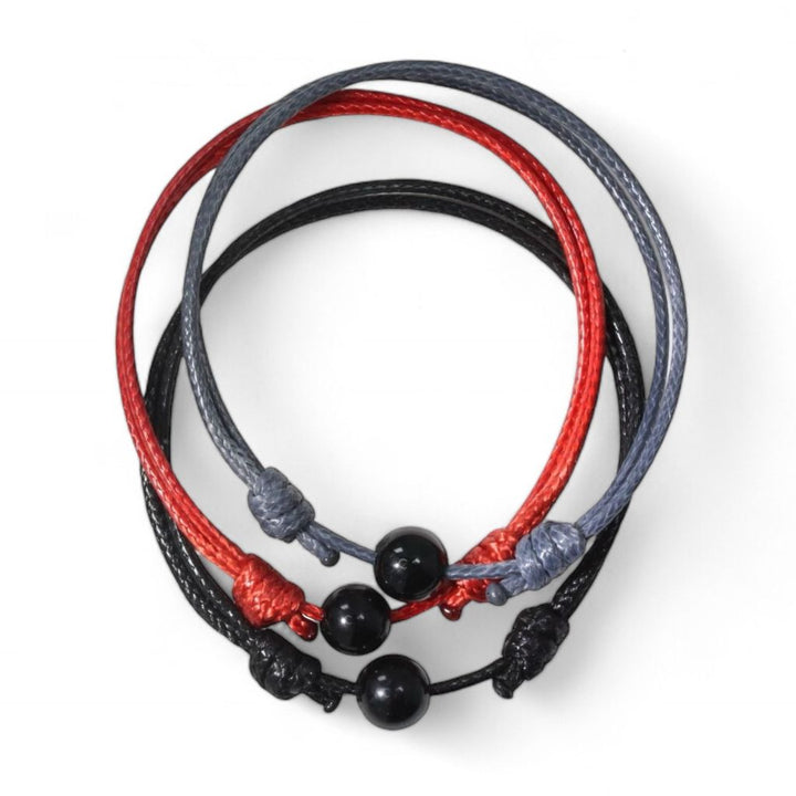 Adjustable black tourmaline bead bracelet with red and gray cord variants.
