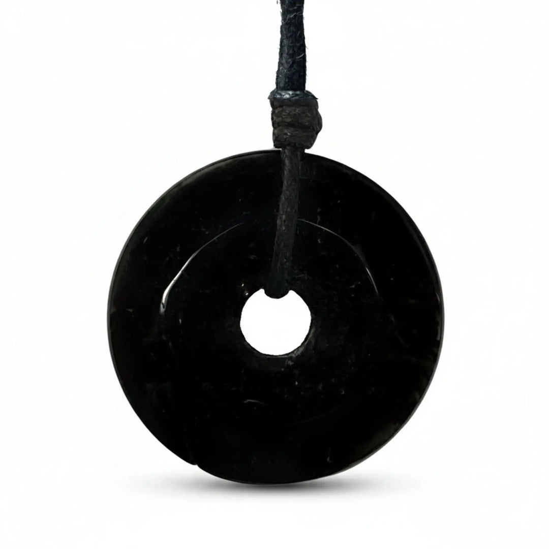 Black tourmaline stone pendant on a white background