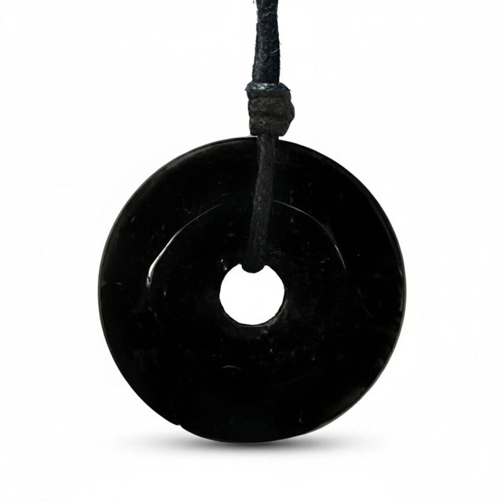 Black tourmaline stone pendant on a white background