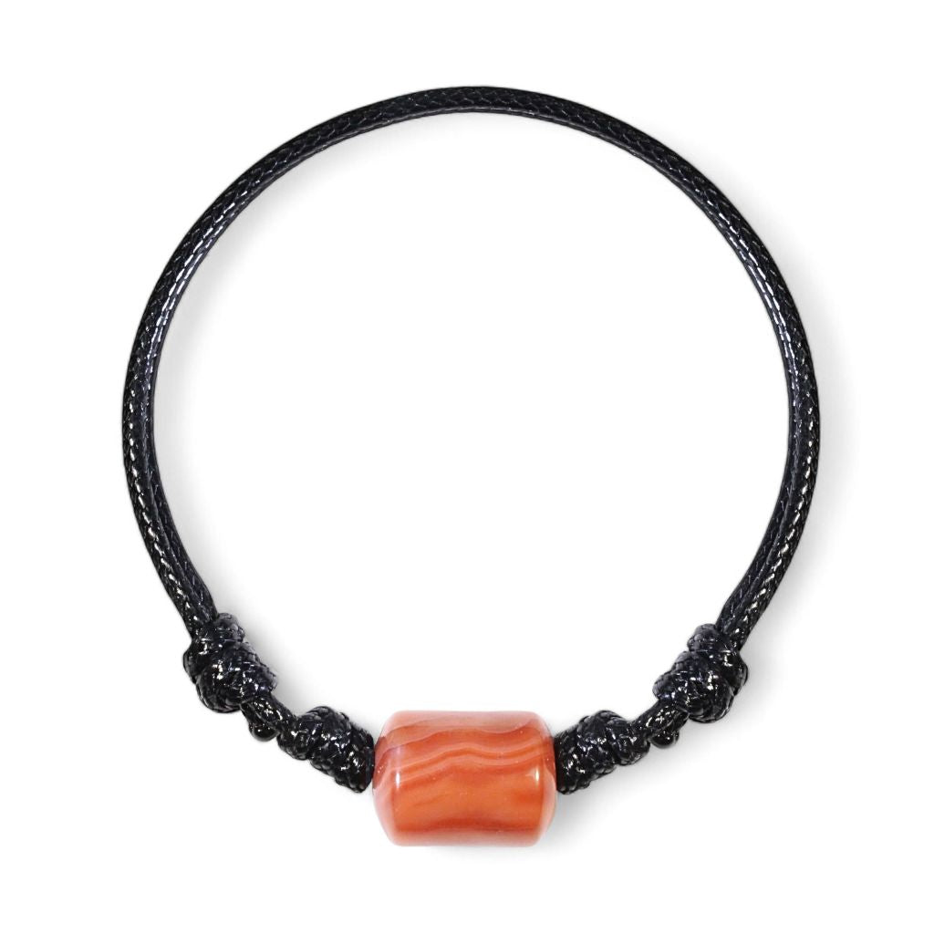Carnelian cylinder bead bracelet on black waxed nylon cord, isolated product view.
