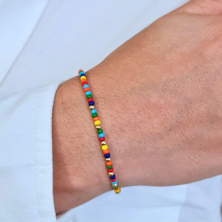Man displaying a 14K Gold Rainbow Beaded Bracelet on his wrist, showcasing its unisex and elegant style - Luck Strings