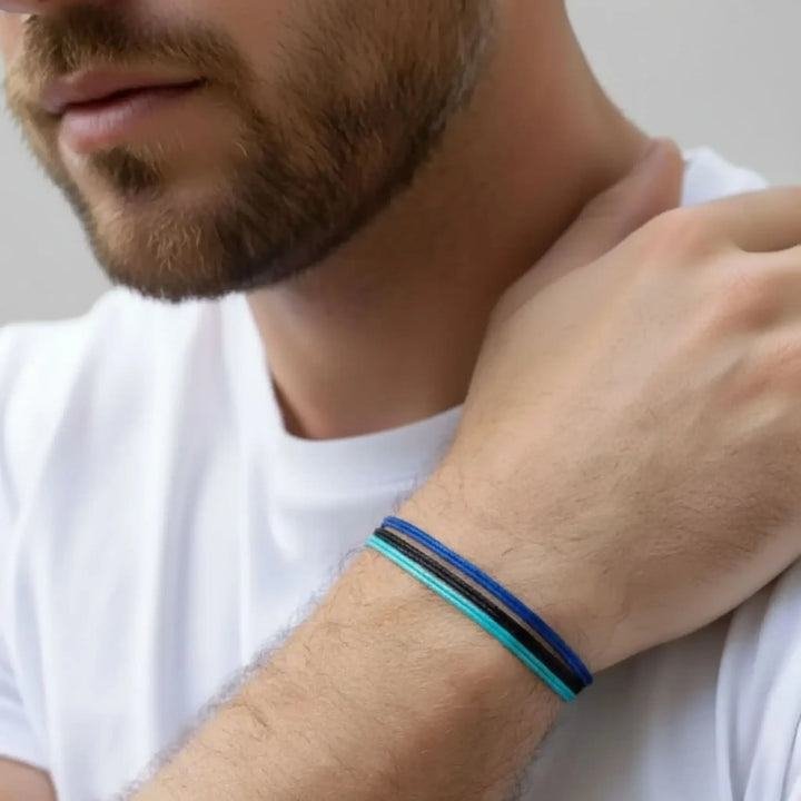 Man wearing a blue and black bracelet on his wrist