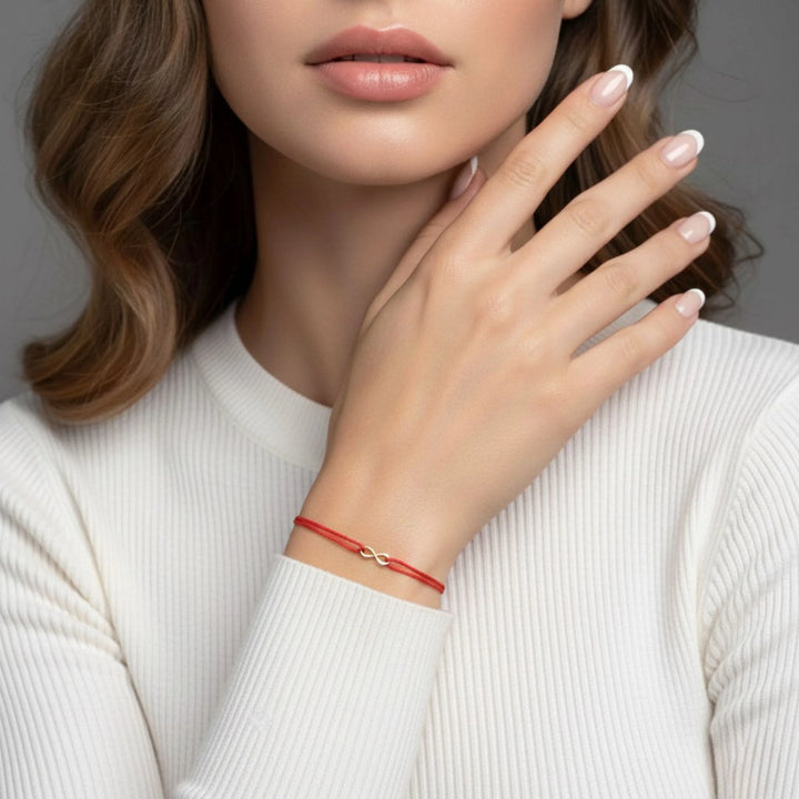 Woman wearing a red bracelet on a neutral background