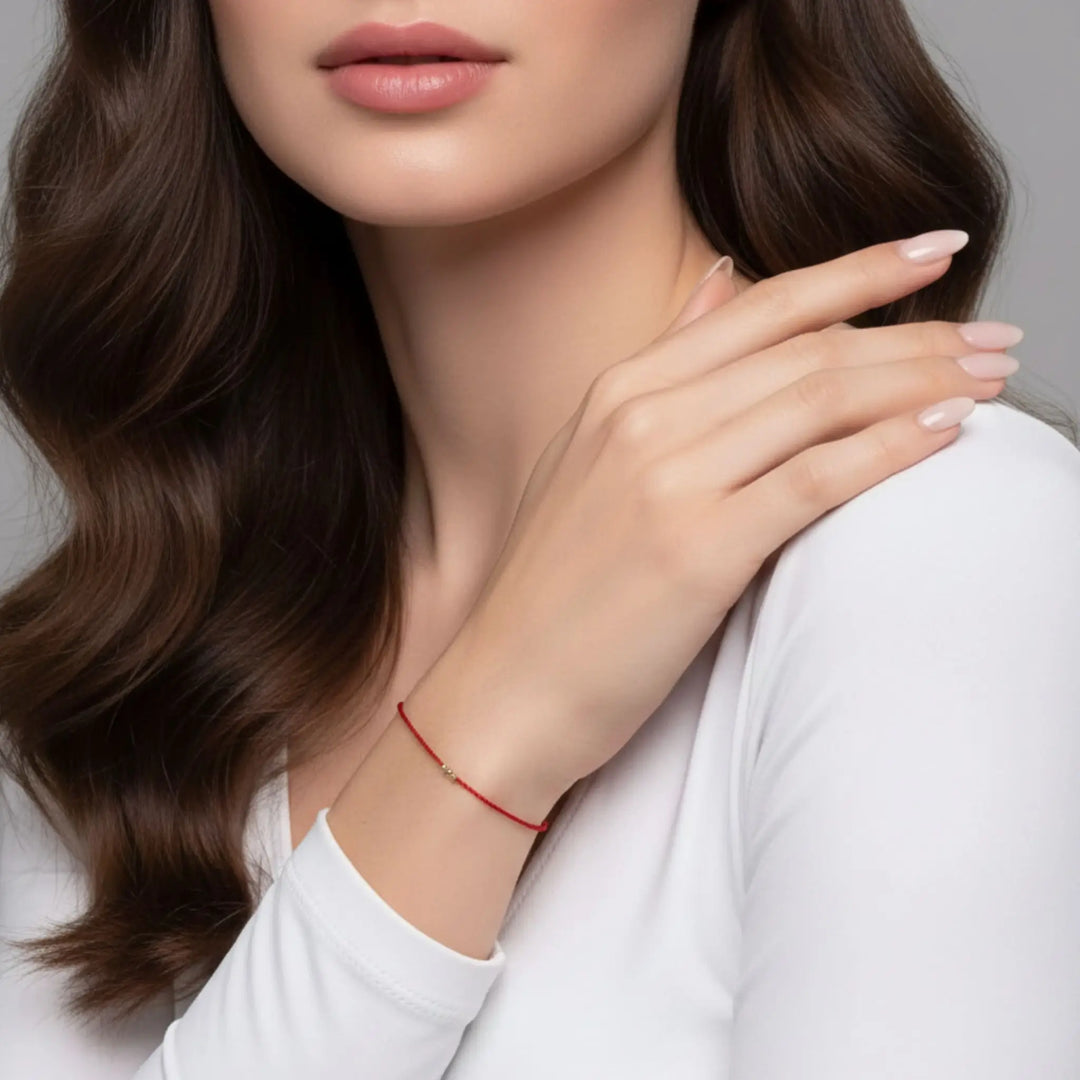 Woman wearing a red bracelet on a neutral background
