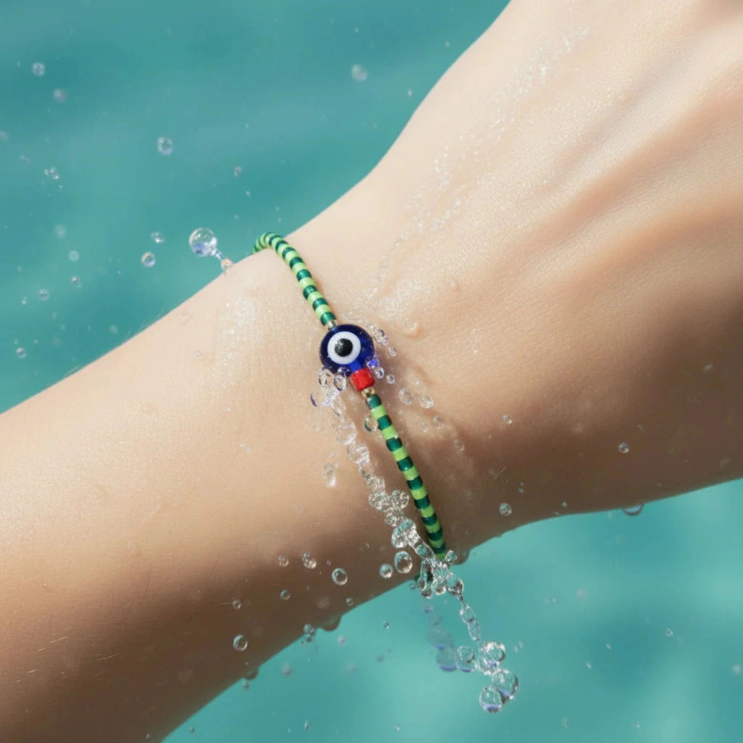 Bracelet with an eye design on a wrist by water