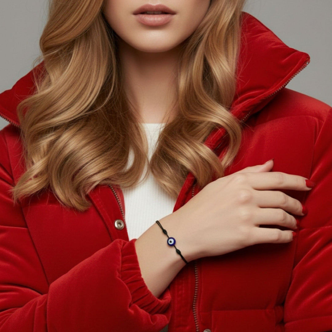 Woman wearing a red jacket with a close-up of her hand and bracelet.