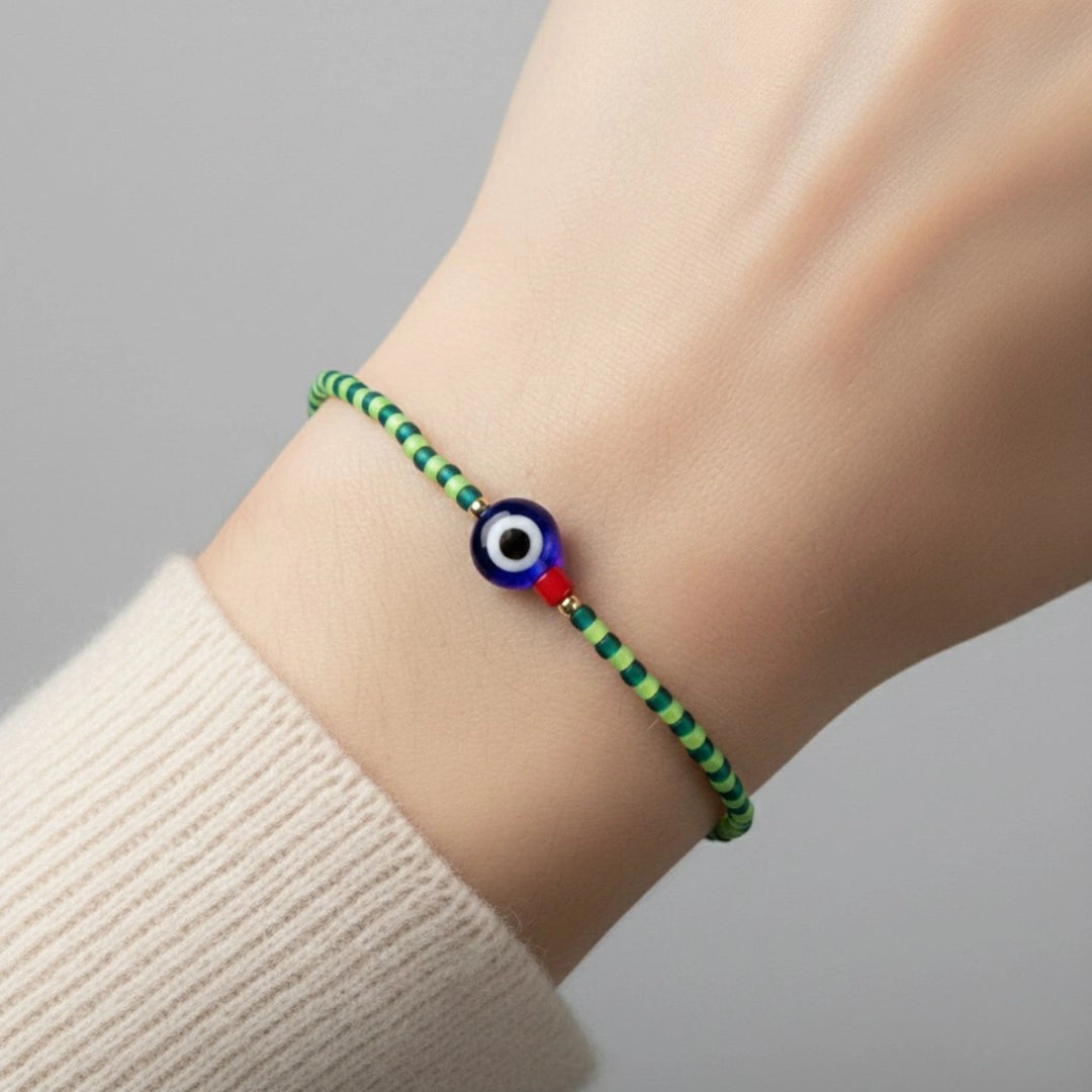 Bracelet with a colorful bead on a wrist against a neutral background