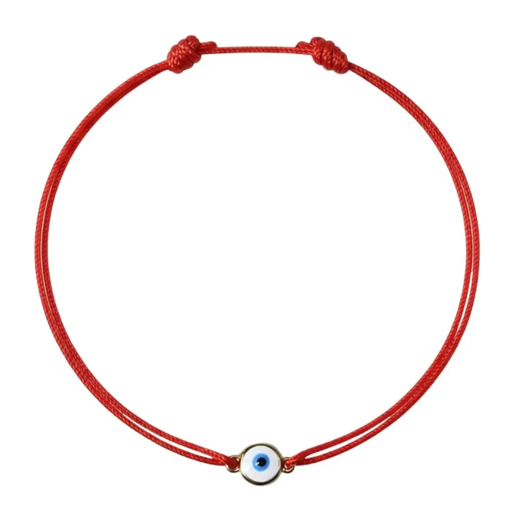 Red string bracelet with a small evil eye charm on a white background