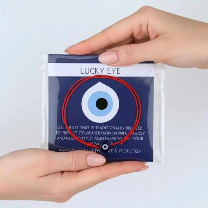 Hand holding a package labeled 'Lucky Eye' with an eye design on a white background