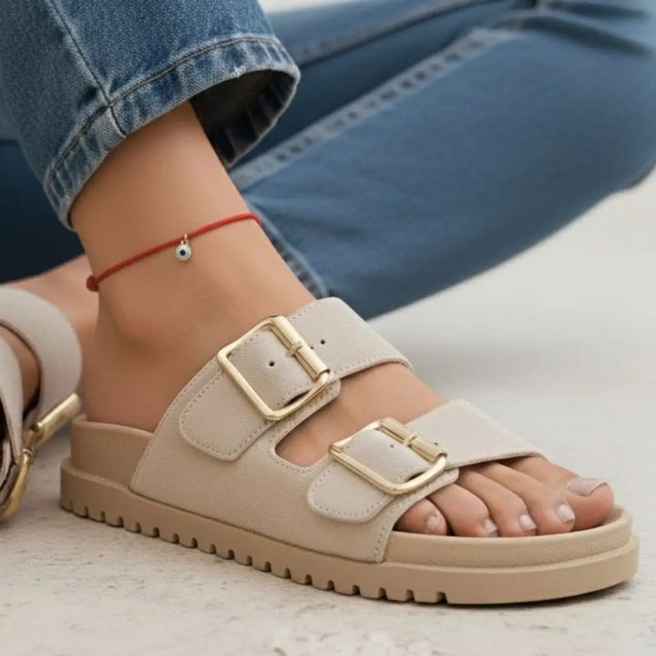 Gold evil eye red anklet  worn by a woman on a light background