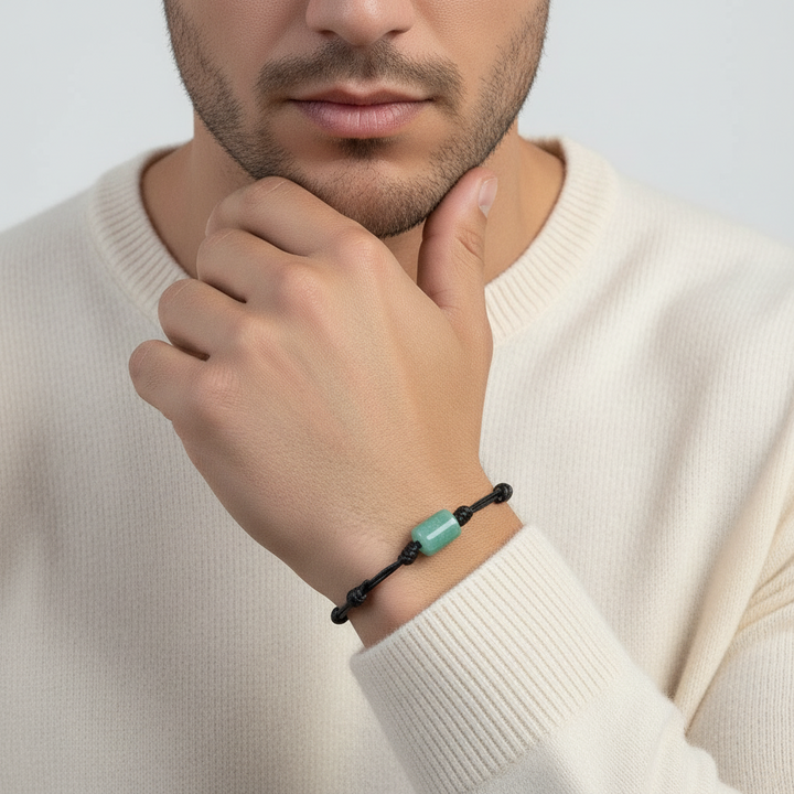 Man wearing green aventurine bracelet on black waxed cord, close-up lifestyle view.
