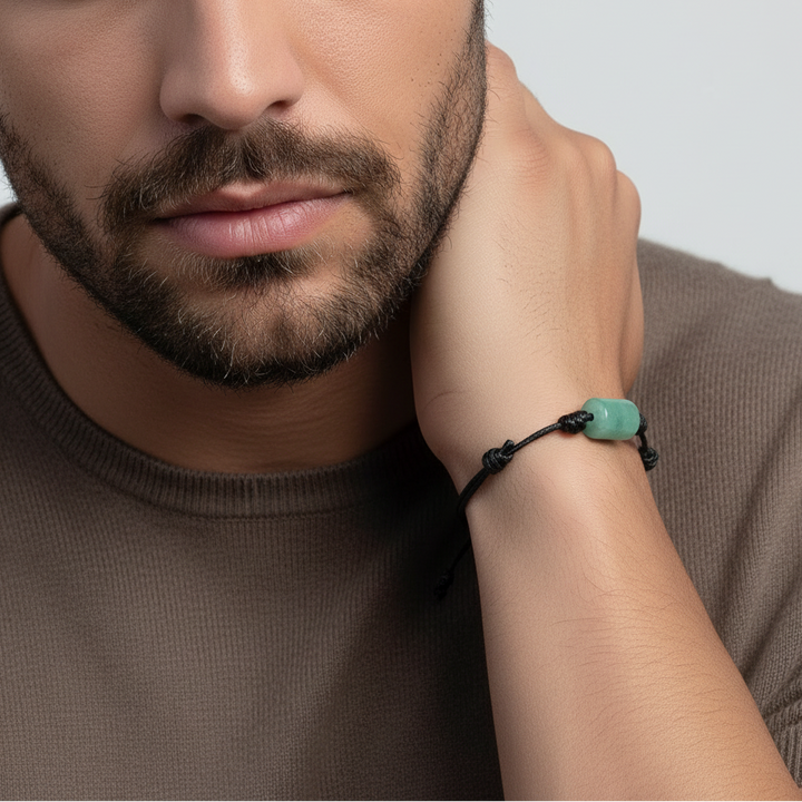 Man wearing green aventurine bracelet on black waxed cord, casual lifestyle view.
