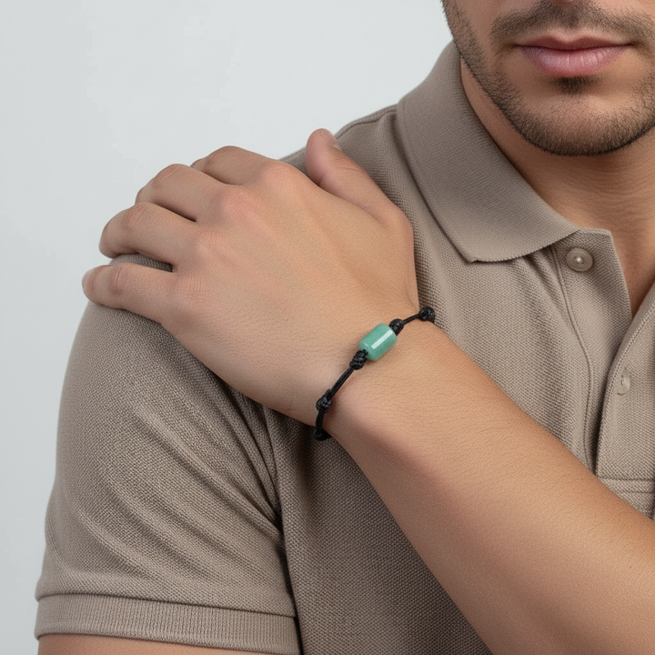 Man wearing green aventurine bracelet on black waxed cord, wrist detail.
