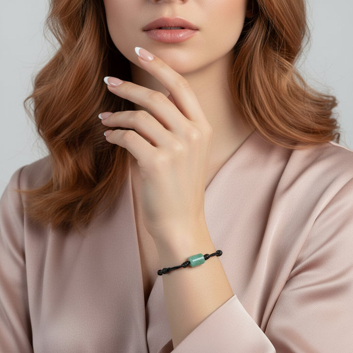 Woman wearing green aventurine bracelet on black waxed cord, close-up of wrist.
