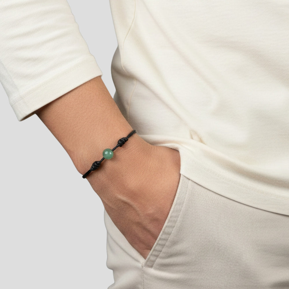 Person wearing green aventurine single bead bracelet on black waxed nylon cord.