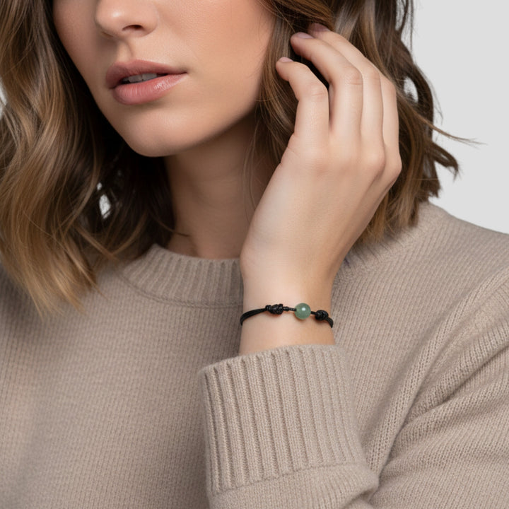 Woman wearing green aventurine single bead bracelet on black waxed nylon cord.