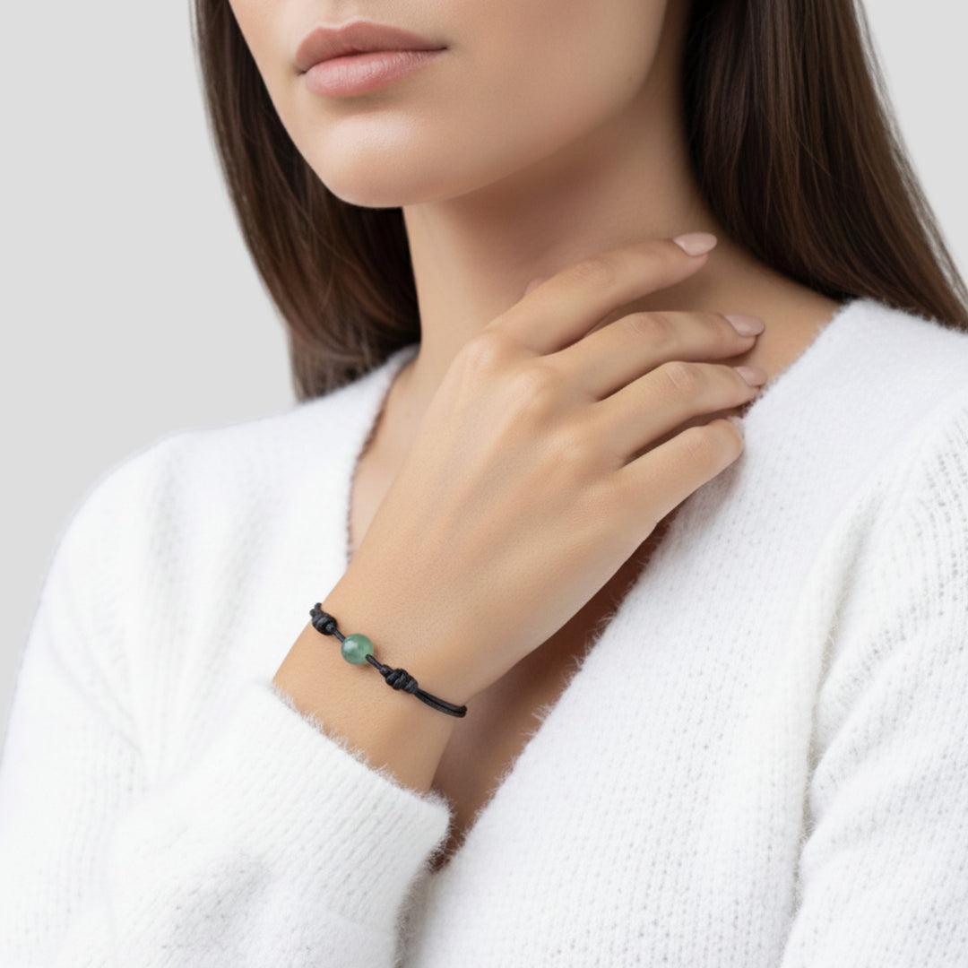 Woman wearing green aventurine single bead bracelet on black waxed nylon cord.
