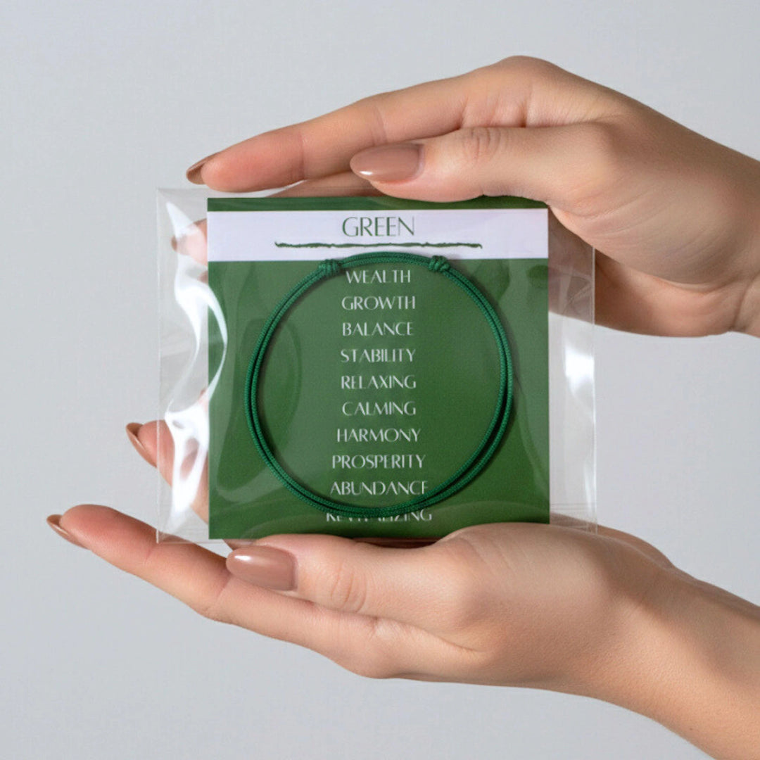 Hand holding a green bracelet in clear packaging with text on a light gray background